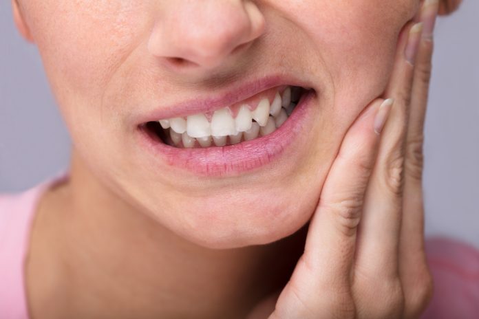 Nahaufnahme einer jungen Frau, die zu Hause unter Zahnschmerzen leidet