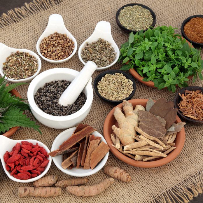 Healing herb and spice selection used in natural alternative herbal medicine for men over hessian background. Selective focus.