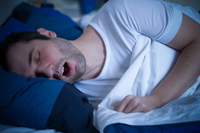 Portrait of man sleeping and snoring loudly lying in the bed