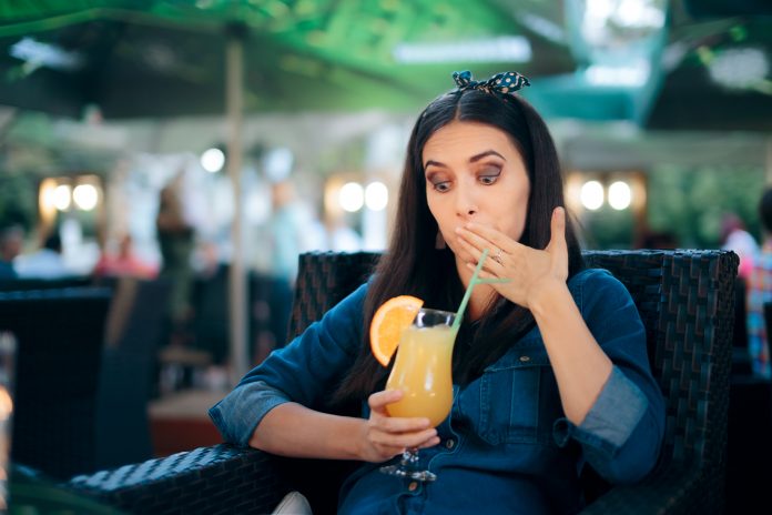 Queasy person having sour beverage to recover