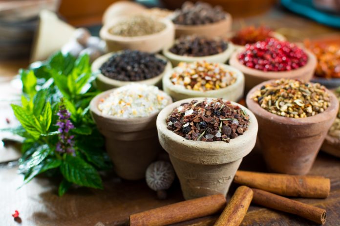Variety of different asian and middle east spices, colorful assortment, on old wooden table, close up
