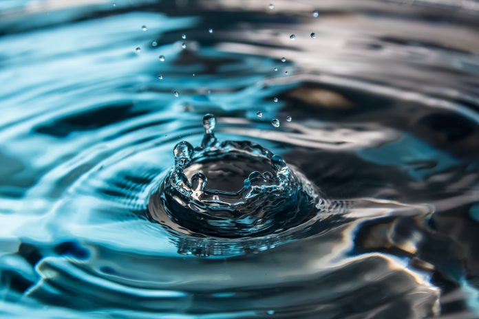Water splash close-up. Crown of blue water. Water drop.