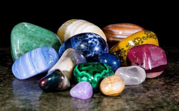 Collection and mix of colorful trumbled mineral stones, gemstones and healing stones