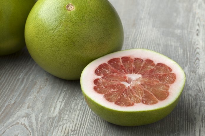 Fresh red whole and half pomelo fruit