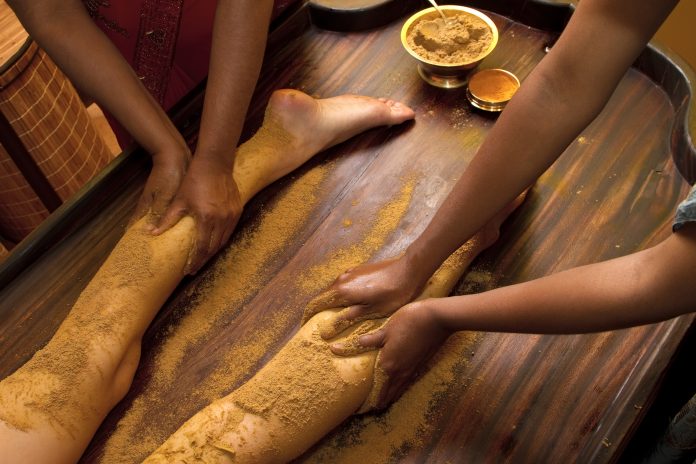 médicos indios realizando el tradicional masaje de pies con aceite ayurvédico
