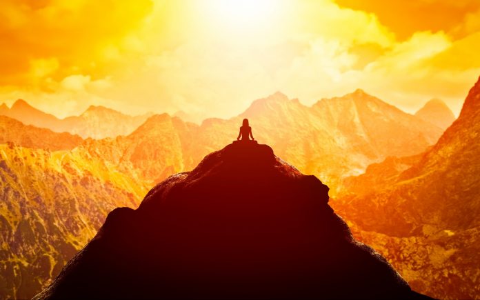 woman-meditating-in-sitting-yoga-position-on-the-top-of-a-mountains-above-clouds-at-sunset-zen-meditation-peace-stockpack-istock
