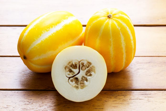Gelbe orientalische Melone auf Holztisch