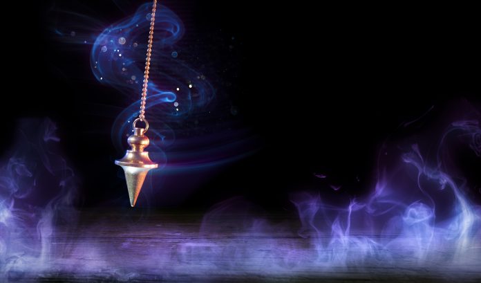 Esoteric And Hypnosis Concept - Pendulum Swinging With Magic Smoke