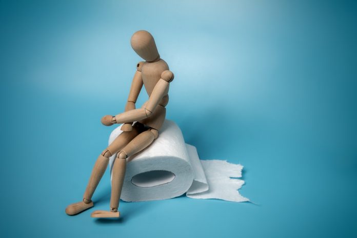 figure of a man sitting on a roll of toilet paper holding his stomach, diarrhea, abdominal pain, food poisoning, intestinal infection