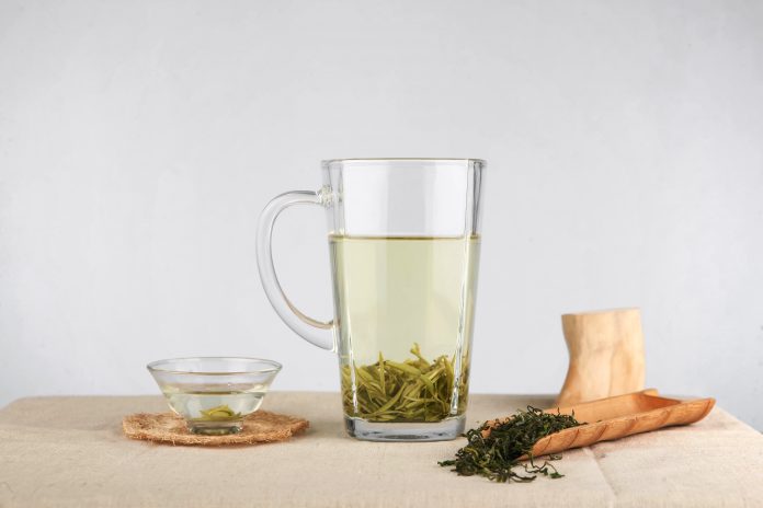 Zaparzona zielona herbata leży na blacie woreczka