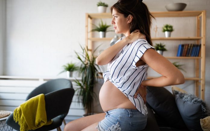 Beautiful pregnant woman expecting baby with pain