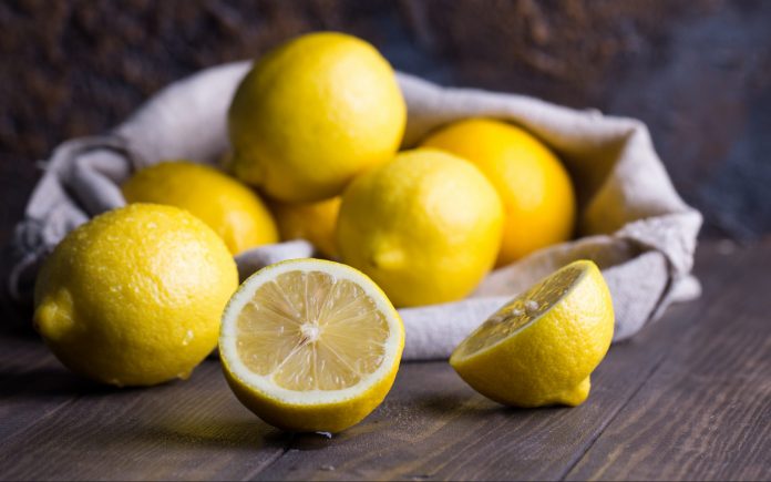 Group of fresh ripe lemon in sackcloth on an old vintage wooden table