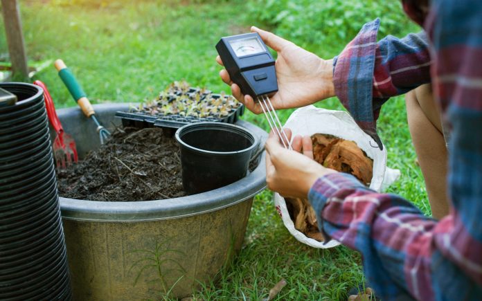 To measure soil pH, gardeners are using a monitor to measure pH balance, acidity, and alkalinity, use of modern agricultural tools. To prepare the soil to mix in vegetable gardening