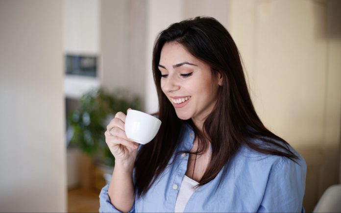 Aufnahme einer jungen Frau bei ihrem Morgenkaffee
