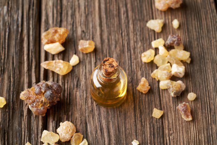 Frankincense essential oil on a wooden background